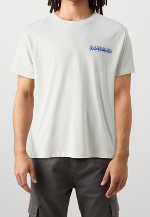 Kortærmet, rundhalset t-shirt i off-white bomuld med blå tekstlogo på venstre bryst. Afslappet pasform med en glat tekstur.