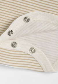 Pruhovaná látka v béžové a krémové barvě se kovovými patentkami u výstřihu. Měkká textura a zaoblené okraje. Detaily zahrnují střídající se pruhy.