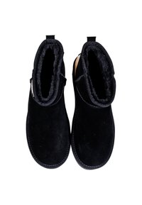 Botines de ante negro con un forro suave y esponjoso y suelas planas. Cuentan con punta redondeada y lengüetas en la parte trasera para facilitar su uso.