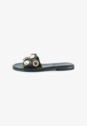 Sandalo scivoloso in pelle nera con una larga fascia decorata con elementi circolari oro e neri, suola piatta e dettagli cuciti lungo il bordo.