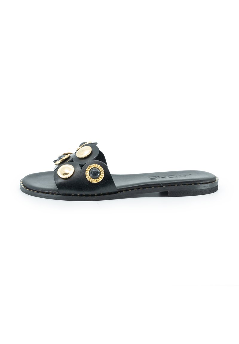Schwarze Leder-Slidesandale mit einem breiten Riemen, der goldene und schwarze runde Verzierungen aufweist, flacher Sohle und genähtem Detail entlang der Kante.