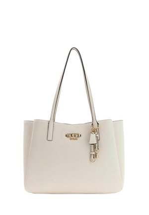 Borsa tote Guess color crema con doppi manici, motivo logo impresso e ciondoli decorativi in tono oro appesi vicino al bordo superiore.