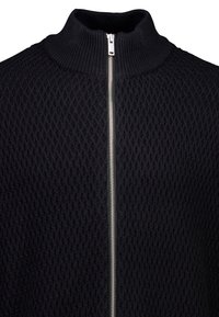 Zwarte gebreide trui met ruitpatroon, hoge ribkraag en zilveren ritssluiting over de volledige lengte aan de voorkant.