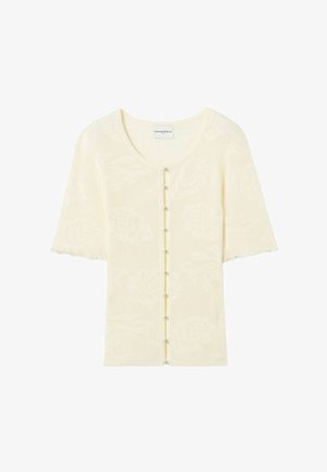 Cardigan en tricot crème à manches courtes avec un motif floral subtil et de petits boutons ronds sur le devant.