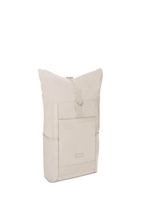 Beige roll-top backpack with front slip pocket, side mesh pockets, and adjustable strap closure.