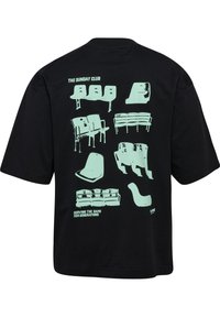 Svart T-shirt med en ljusgrön grafik som visar olika sittdesigns på baksidan, med texten "THE SUNDAY CLUB" och "SERVING THE GAME FOR GENERATIONS."