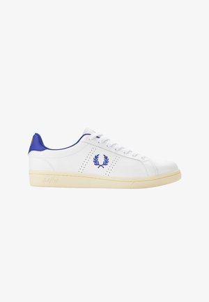 Zapatilla blanca de cuero de perfil bajo con logo de laurel azul, lengüeta azul en el talón, cordones blancos y suela de goma color crema, vista lateral.