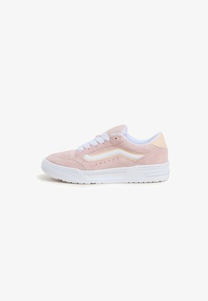 Jasnoróżowy zamszowy sneaker z białymi sznurowadłami, białą gumową podeszwą i białym paskiem wzdłuż boku.