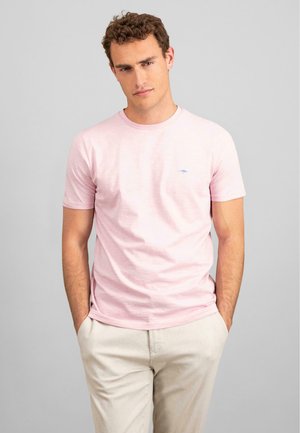 Tricou roz cu mânecă scurtă și guler rotund, având un mic logo albastru pe piept. Textură moale, croială lejeră, asortat cu pantaloni deschiși.