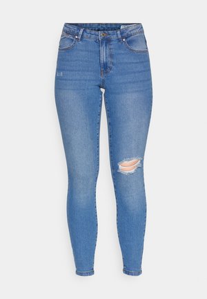 Jeans subțiri din denim albastru cu un finisaj decolorat, dotate cu o genunchiere distrusă cu margine destrămată, buzunar frontal și bucle pentru curea.