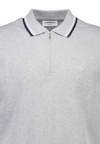 Grå polo skjorta med dragkedja vid kragen, med marinblå och vita randiga accenter. Tillverkad av mjukt tyg, har den en avslappnad passform och broderad logotyp.