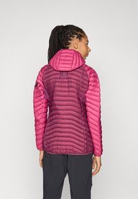 Chaqueta acolchada en tonalidades degradadas de rosa con capucha. Presenta una textura acolchada y un corte slim. Incluye cremallera y acentos en las mangas.