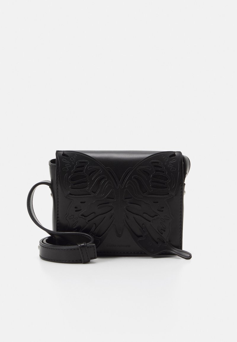 Borsa in pelle nera con un design a farfalla in rilievo sul davanti. Presenta una tracolla staccabile e una forma rettangolare. Texture liscia, stile minimalista.