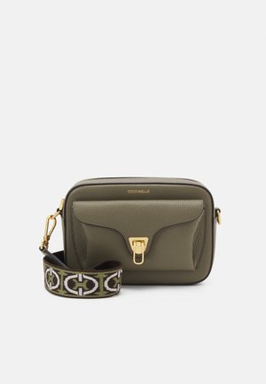 Olivegrüne Leder-Umhängetasche mit goldfarbenem Verschluss, Vordertasche und gemustertem, verstellbarem Schulterriemen auf weißem Hintergrund.