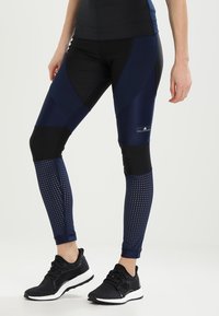 Navy urheilulegginsit, joissa on tiukka muotoilu ja tekstuurilla varustettu verkkopaneeli sekä kontrastiosia mustana ja tummansinisenä. Sopii aktiiviseen käyttöön.