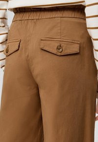 Brown trousers van gladde stof, met twee achterzakken met knoopsluiting, een elastische tailleband en een relaxte pasvorm.