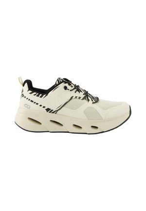 Lichtbeige sneaker met zwart-witte zebrastripes op het vetergedeelte en hiel, zwarte binnenvoering, gevoerde zool met zijuitsparingen.