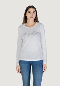 T-shirt bianca a maniche lunghe con testo "Lingo" in glitter argento, caratterizzata da un collo arrotondato e una trama in tessuto morbida e liscia.