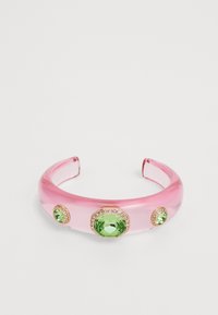 Pink transparent acrylic hairband with green gemstone embellishments. Features two smaller and one larger stone framed in gold accents.