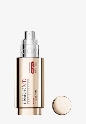 Gold-toned pump bottle labeled Absolute Longevity MD Reset The Serum with detached round cap on a white background.