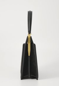 Sac à main en cuir noir et daim avec un design rigide et structuré, présentant un accent en matériel doré et une poignée supérieure.