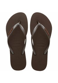 Chanclas de goma marrón con una suela texturizada, tiras marrones en forma de V y el logo de Havaianas exhibido de manera prominente en cada suela.