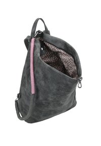Sac noir texturé avec une sangle d'accent rose, ouverture zippée et un motif intérieur à pois. Présente une forme triangulaire moderne.