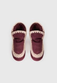 Pantofole in suede bordeaux con una morbida fodera interna, dotate di bordo all'uncinetto color crema e un design oversize e svasato.