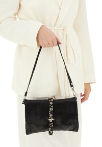 Borsa a mano nera in pelle con design piatto, superficie testurizzata, tracolla regolabile e dettagli metallici decorativi lungo la chiusura.