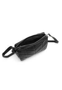 Borsa nera in pelle trapuntata con chiusura a zip e manico corto. Presenta una superficie liscia e una tasca interna, adatta per piccoli oggetti.