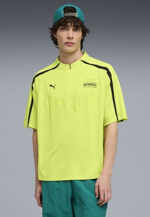 Neon-gelbes Kurzarmhemd mit schwarzen Akzenten, mit hohem Kragen und einem Logo auf der Brust. Glattes, leichtes Material.