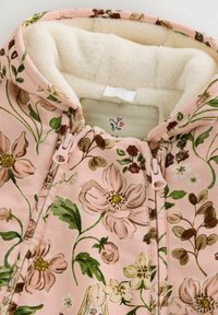 Sudadera con cremallera de flores en tonos rosas, con un suave forro de felpa en color crema. Presenta un patrón detallado de flores y un cierre de cremallera en un rosa claro.