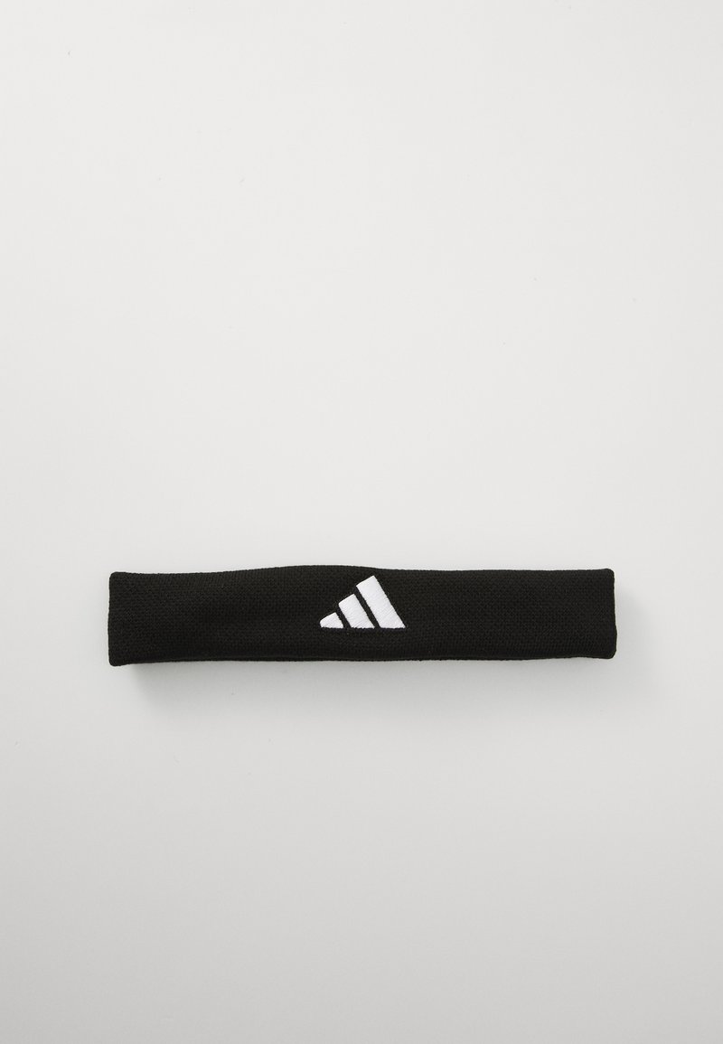 Melnā galvas lente, kas izgatavota no teksturēta auduma, ar baltu Adidas logo un trim svītrām vienā pusē. Garums ir aptuveni 25 cm.
