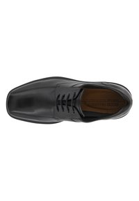 Chaussure de ville en cuir noir avec un bout arrondi, lacets à l'avant, texture lisse et détails de couture minimaux. L'intérieur présente une semelle en cuir marron.
