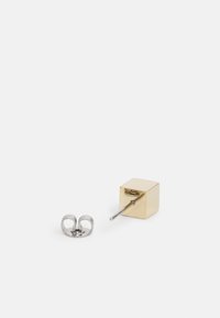 Orecchino in metallo dorato con design a cubo e retro in argento. Il cubo è liscio con una finitura lucida, mostrando un'estetica moderna.