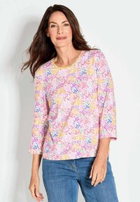 Lichtgewicht top met driekwart mouwen, met een roze achtergrond en veelkleurige abstracte bloemenpatronen. Klassieke ronde halslijn, gladde textuur.