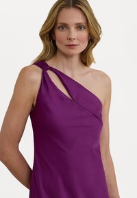 Satin, enaxlad klänning i ljus lila, med en tvistad axeldetalj och en figurnära silhuett. Slät textur och elegant fall.