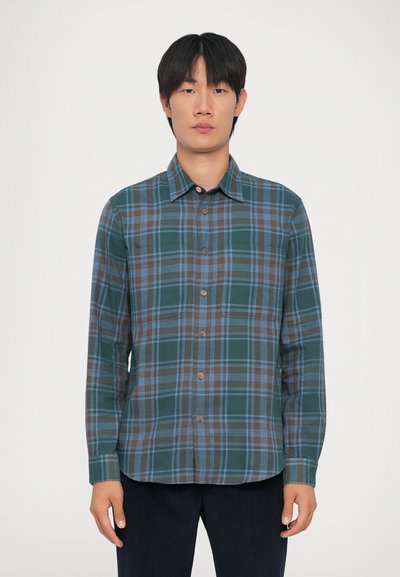 Camisa de cuadros verde con acentos en azul y marrón, de mangas largas y con dos bolsillos en el pecho. Hecha de una tela suave y tejida.