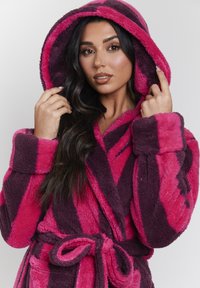 Ropa de baño con capucha difusa y rayas en rosa oscuro y púrpura, que incluye un cinturón de lazo y una textura suave, con una gran capucha y puños anchos.