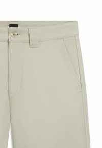 Pantaloni beige realizzati in un tessuto liscio e testurizzato con trama diagonale, chiusura con bottone e due tasche laterali.