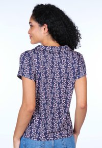 Navy floral t-shirt featuring a fitted design, short sleeves, and a smooth texture. The pattern includes small pink flowers and green leaves.