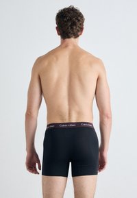 Čierne bavlnené boxerky s priliehavým strihom a jednofarebným tmavohnedým pásom s bielym logom "Calvin Klein".