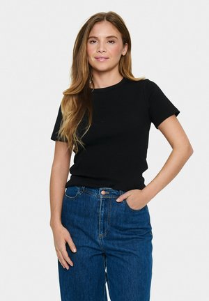 T-shirt nera a maniche corte con scollatura rotonda e silhouette aderente, abbinata a jeans blu in denim a vita alta.