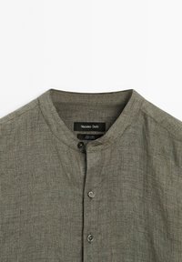 Gray linen shirt with a round collar and button closure, featuring the Massimo Dutti label inside at the neckline.