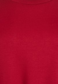 Červená látka s hladkou textúrou a jemným leskom. Dizajn má jednoduchý, klasický strih bez vzorov alebo viditeľného kovania.