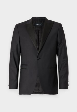 Black blazer with a notch lapel, single button, structured design, textured fabric, and two front pockets. Lined interior with a pattern.