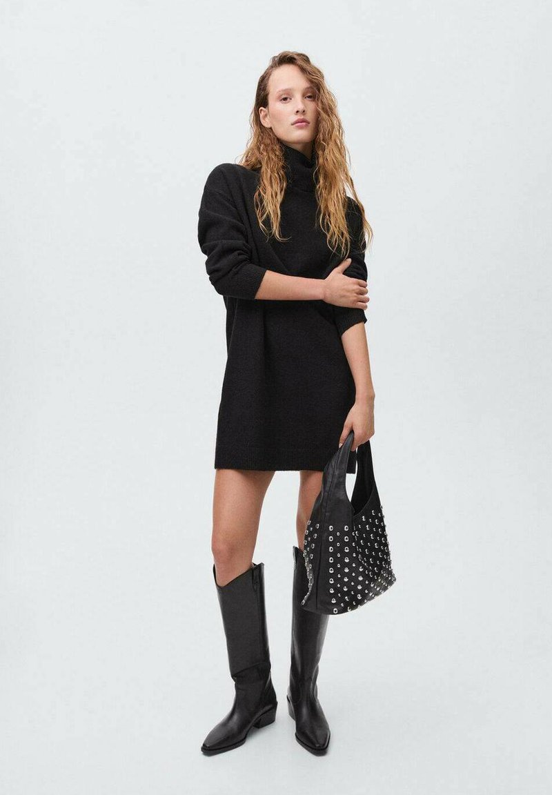 Černé oversized svetr šaty s rolákem, ve spojení s černými koženými botami až ke kolenům a černou kabelkou se hroty. Hladká textura, moderní design.