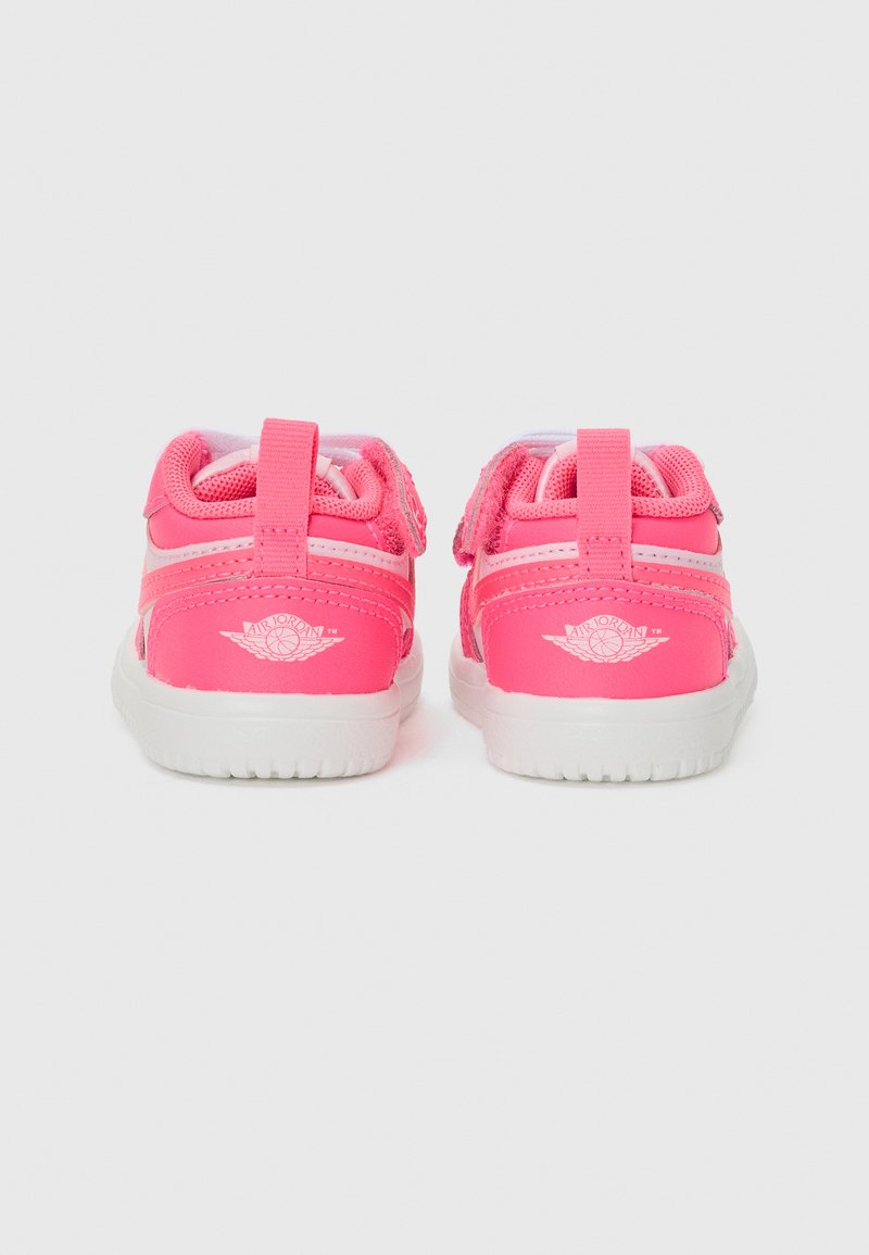 Scarpe da ginnastica rosa con tomaia in sintetico, dettagli in rete e suola in gomma bianca. Presentano una striscia in velcro e un logo sul tallone.