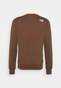 Sudadera de cuello redondo marrón hecha de tela suave. Presenta puños y dobladillo acanalados, con un pequeño logo en la parte superior del hombro izquierdo.