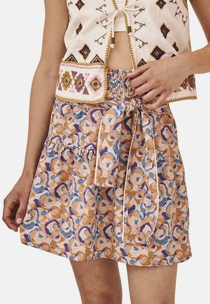 Falda corta en línea A con un patrón floral multicolor en naranja, azul y púrpura. Presenta una cintura fruncida y un detalle de lazo atado.